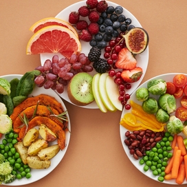 Three plates willed with a colorful mix of fruit and vegetables.