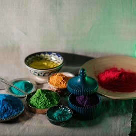 7 bowls filled with a variety of different powdered colors.