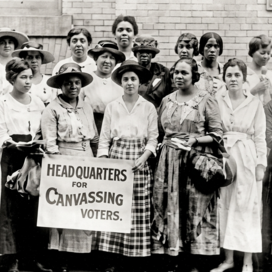 A black and white photo of a group of African American women carrying a sign for voter rights during the suffrage movement in the early 1910's
