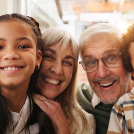 grandparents and grandchildren pose together for a photo. 