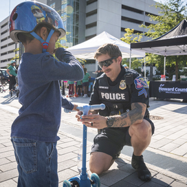 Officer helps a young child with a scooter